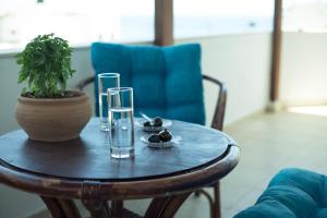 a table with two glasses and a potted plant on it at Sunset Home Crete in Paránimfoi