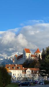 un gran edificio en la cima de una colina con coches aparcados en Pictures, en Füssen