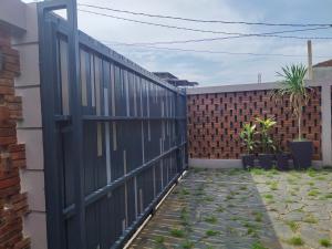 a black fence in front of a brick wall at Tropical Cozy House in the heart of Medan in Medan