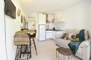 ein Wohnzimmer mit einem Sofa und einem Tisch in der Unterkunft Apartamento con jardincito en el centro de CADAQUÉS in Cadaqués