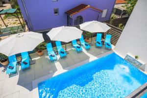 uma vista superior para uma piscina com cadeiras e guarda-sóis em Valla Studio Apartments em Fažana