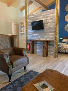 a living room with a couch and a tv on a wall at El Habar de Pria in La Pesa