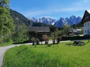 a gazebo in a field with mountains in the background at Ferienwohnungen Asterbach in Gosau