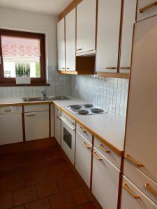a kitchen with white cabinets and a stove top oven at Apartment Ananas I Zentral & SeeNah in Pörtschach am Wörthersee