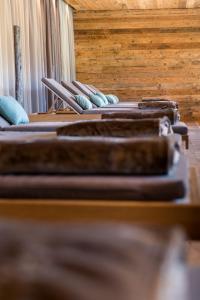 una fila de mesas marrones con almohadas azules. en Hotel Gran Paradiso, en San Cassiano