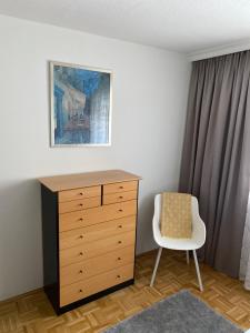 a bedroom with a dresser and a chair at Apartment Ananas I Zentral & SeeNah in Pörtschach am Wörthersee