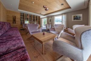 a living room with chairs and a couch and a table at Ciampedie Luxury Alpine Spa Hotel in Vigo di Fassa