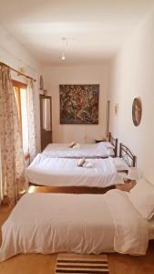a room with three beds and a painting on the wall at Cosmema House 1 Hot tub and swimming pool villa in Stroumbi