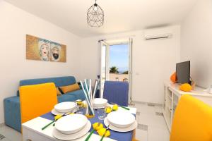a living room with a table and yellow chairs at My home Capri in Capri
