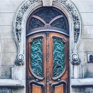 une porte en bois décorée dans un bâtiment dans l'établissement La Maison de L' Ambassadeur Carcassonne B&B, à Carcassonne