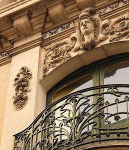un bâtiment avec une fenêtre sur laquelle se trouve une statue dans l'établissement La Maison de L' Ambassadeur Carcassonne B&B, à Carcassonne