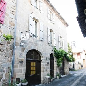 um edifício de pedra com um sinal na lateral em Le Pressoir chambres d'hôtes em Cardaillac