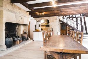 a kitchen with a wooden table and a fireplace at Le Pressoir chambres d'hôtes in Cardaillac