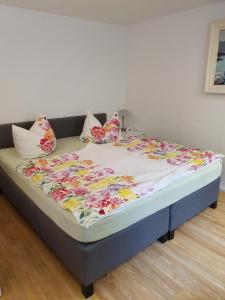 a bed in a room with a flowery blanket on it at Erftmündung in Neuss