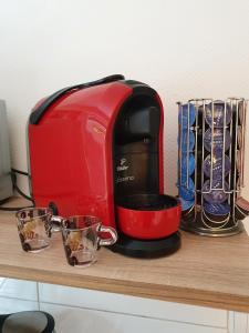 a red toaster sitting on a counter with two cups at Erftmündung in Neuss