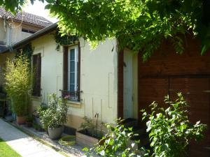 une maison blanche avec des plantes devant elle dans l'établissement Studio ville très calme, à Tarbes