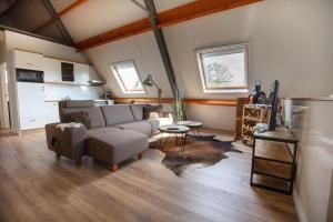ein Wohnzimmer mit einem Sofa und einem Tisch in der Unterkunft Vakantiehuis De Drie Bruggen in Valkenswaard