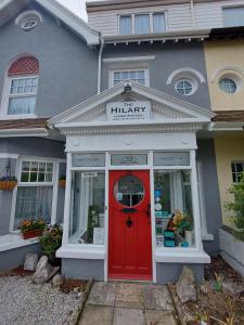 een winkel met een rode deur in een huis bij The Hilary Guesthouse in Llandudno