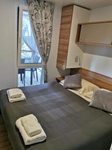 a bedroom with a large bed with two towels on it at Mobile Home Erna, Rovinj in Rovinj