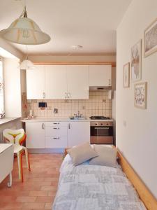 a kitchen with white cabinets and a bed in a room at Borgo Castelluccio Country House in Porretta Terme