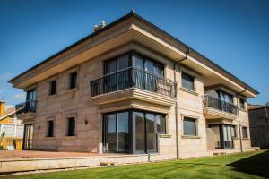 ニグランにあるPORTO & AMERICA.のバルコニー付きの大きなレンガ造りの建物