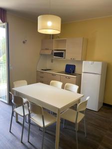 La cuisine est équipée d'une table, de chaises et d'un réfrigérateur. dans l'établissement Appartamento IL POGGIO, à Tortoreto Alto