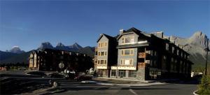 a large building on a street with mountains in the background at Apartment 407, Contemporary Decor in Canmore