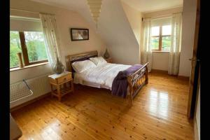 una camera da letto con un letto e un pavimento in legno di Annies Meadow. a Knock