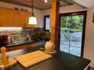Muntele Cacovei的住宿－Mountain Chalet - Cabana la Muntele Baisorii，厨房在柜台上设有切板