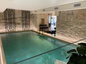 a large pool of water in a room with a stone wall at Hotel Spa Genovese in Bonifacio