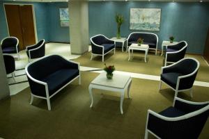 Hotel Chacao Cumberland في كاراكاس: غرفة انتظار مع كراسي وطاولات في مستشفى