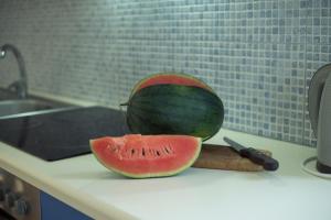 a watermelon sitting on a counter next to a knife at Sunset Home Crete in Paránimfoi