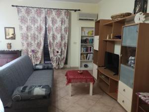 a living room with a couch and a television at Relax House in Giardini Naxos