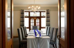 a dining room with a table with chairs and a chandelier at Saint James on Venice in Durban