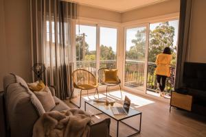 ニグランにあるPORTO & AMERICA.の窓際のリビングルームを見下ろす女性