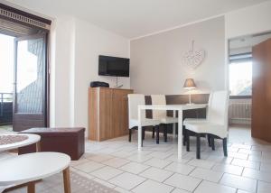 Una sala de estar con una mesa y sillas blancas. en Welcome in - Apartments Am Waltenberg 57-59, en Winterberg