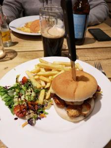 a white plate with a sandwich and french fries at Lochindaal Hotel in Port Charlotte