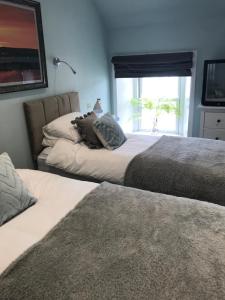 a bedroom with two beds and a window with a view at Lochindaal Hotel in Port Charlotte