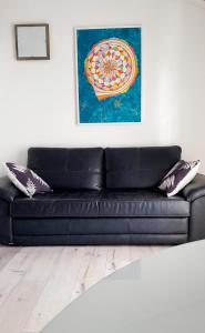 a black leather couch in a living room with a painting at Sia House in Pula