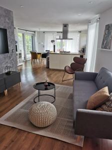 a living room with a couch and a table at Modernes Ferienhaus im Schwarzwald in Freiamt