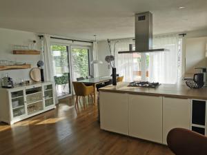 a kitchen with white cabinets and a table with chairs at Modernes Ferienhaus im Schwarzwald in Freiamt