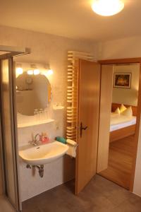 a bathroom with a sink and a mirror and a bed at Landhotel Gasthof zur Post in Winterberg