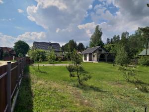 een tuin met een hek en een huis bij Mazury domek całoroczny Pelnik gm Ostróda jezioro las in Pelnik