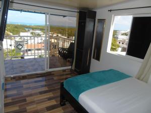 Schlafzimmer mit einem Bett und Blick auf einen Balkon in der Unterkunft Mi buena Vista in San Andrés