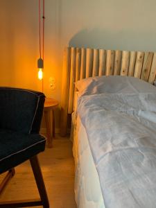 a bedroom with a bed and a chair and a lamp at Strandhaus WOTAN in Kühlungsborn