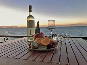 a plate of fruit and a bottle of wine on a table at Aliki Studios in Boukari