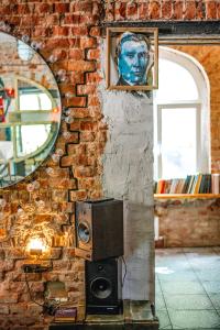 a brick wall with a mirror and a speaker at Tolstoy Art-Hostel in Kaliningrad