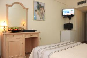 a bedroom with a bed and a television at Hellinis Hotel in Athens