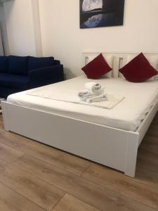 Una gran cama blanca con almohadas rojas. en Beside Airport, en Otopeni