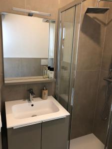W łazience znajduje się umywalka i prysznic. w obiekcie Marine House w Lignano Sabbiadoro